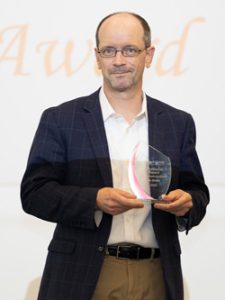 photo of professor Ian Drake holding award