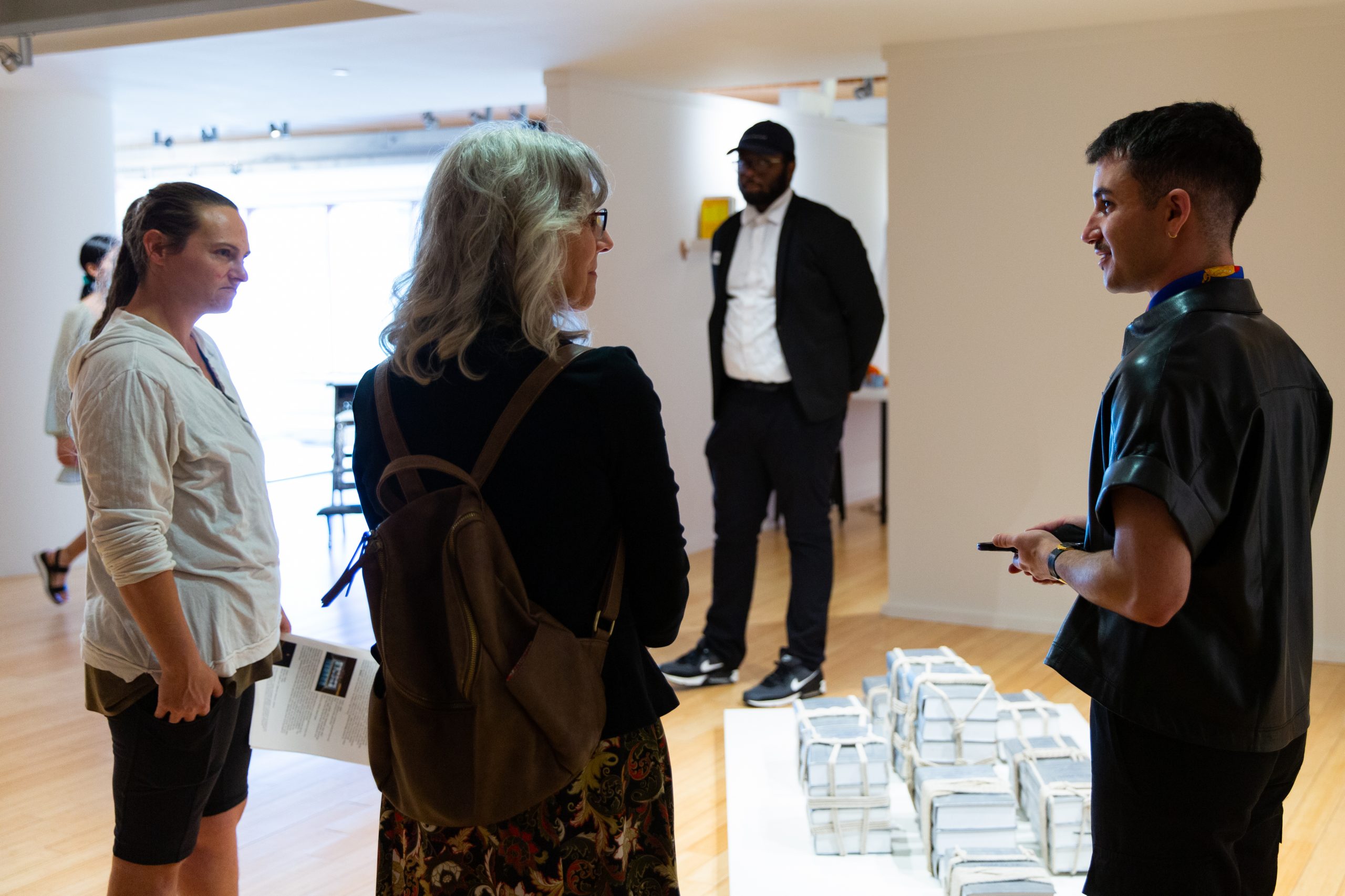 Artist Joseph Liatela speaks to visitors about one of the works in the Segal Gallery.