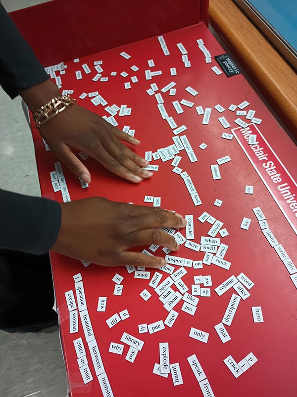 Hands arranging poetry magnets