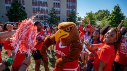 Rocky the Red Hawk dancing with students