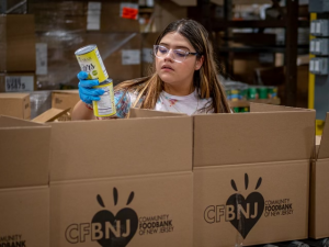 NextGen student packing non-perishable foods in a box.