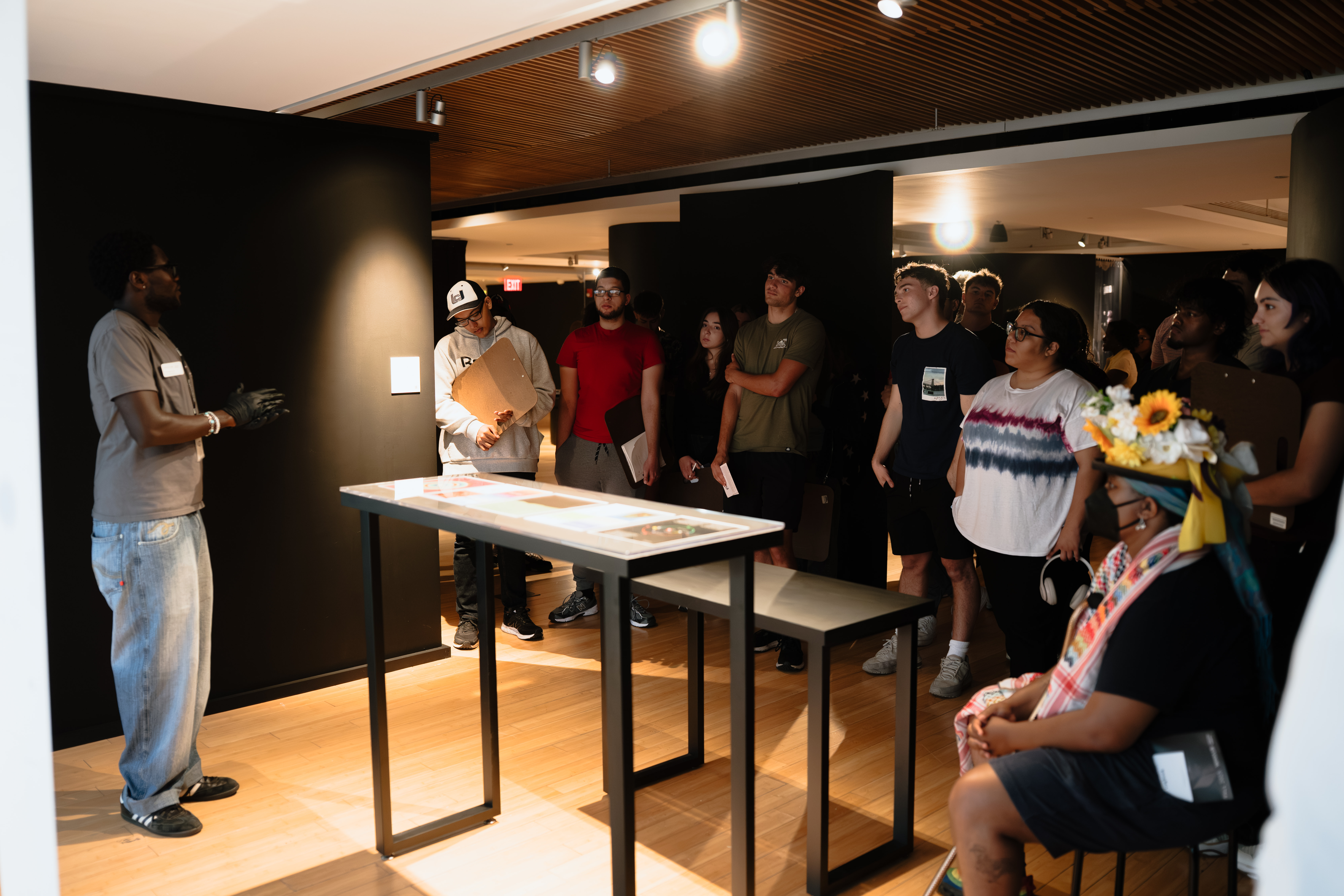 A docent speaks to a class about an artwork.