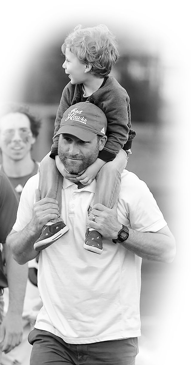 Coach Schambach with son on his shoulders.