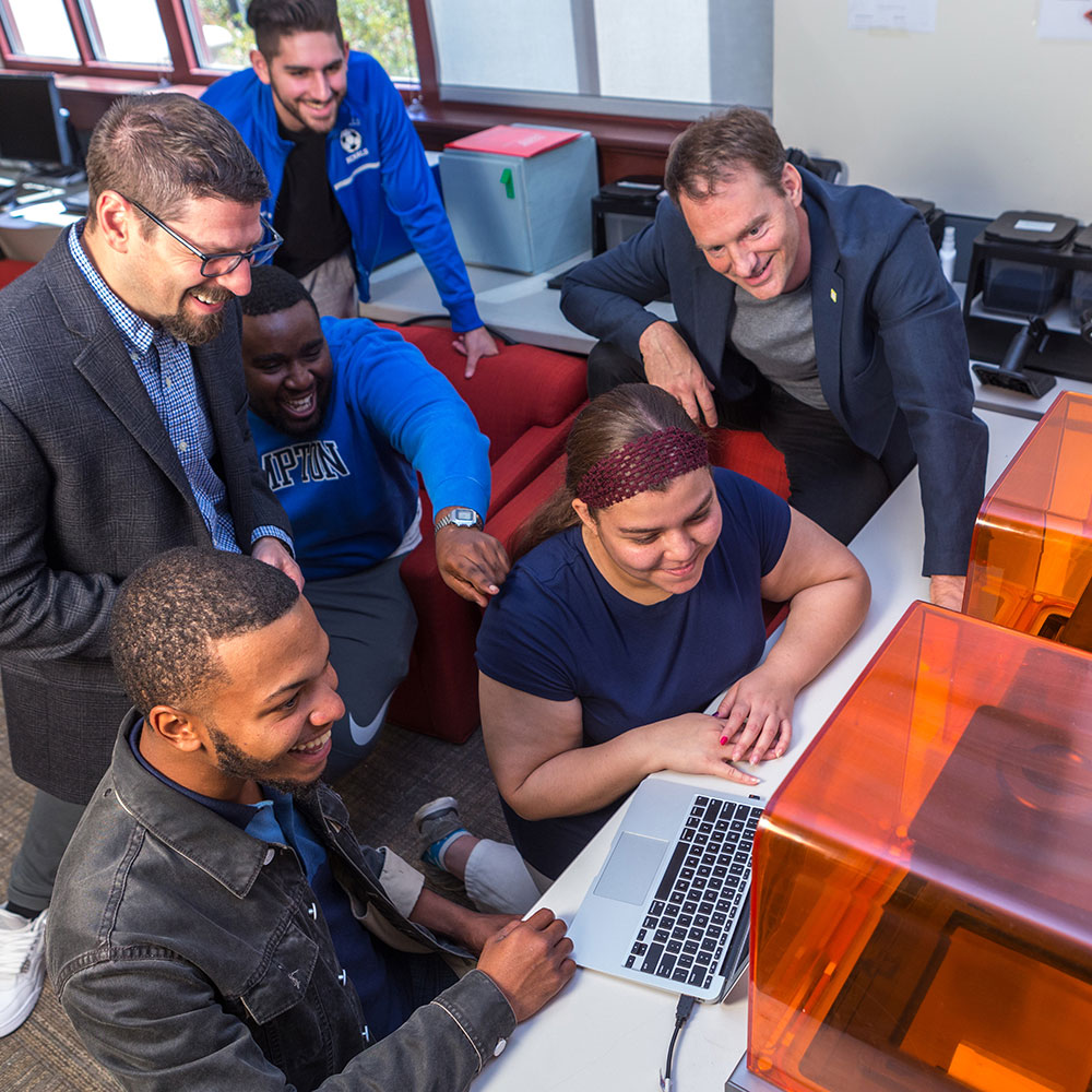 MSU students and professors gathered around computer and 3D printers