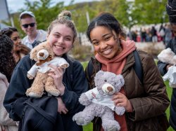 Two students holding teddy bears