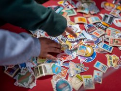 Photo of hands sorting through stickers featuring multiple languages