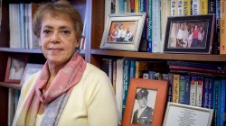 Photo of Professor Deborah Ragin in front of bookshelf with books and picture frames