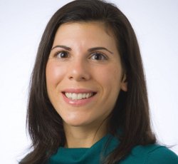 headshot of professor Laura Lakusta in green top and white background