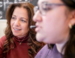 Elaine Hitchcock with student, engaging in student's work