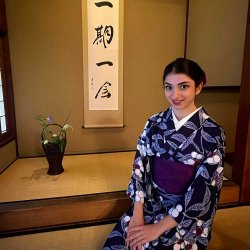 Melissa Spigelman in a kimono by Japanese sign saying "Once in a Lifetime"