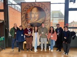 Group of students standing for photo in front of William Shakespeare Tapestry