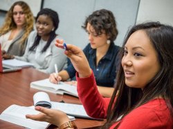 student speaks while classmates listen and take notes