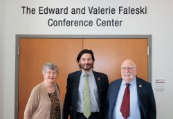 The Faleskis pose with President Koppell in front of the conference room named after them.