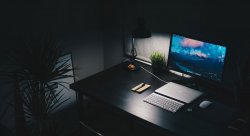 laptop with monitor in dark room on black desk