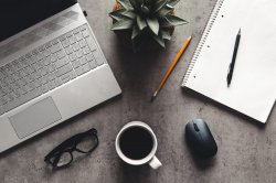 laptop and book, coffee on gray background, Top view of office desk on textured gray background