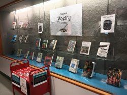 Books displayed in front national poetry month sign