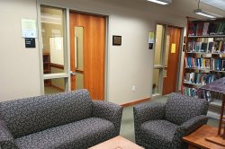 2 group study rooms with a table and couches outside of them