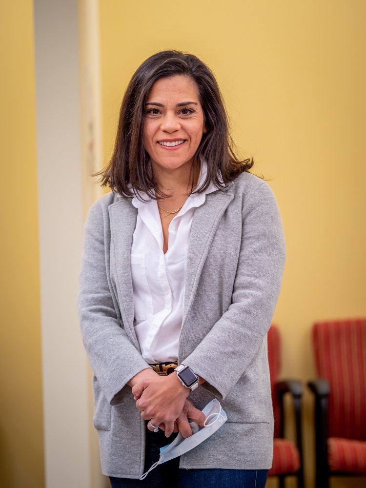 A woman smiles while looking at the camera.