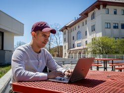 Person sitting with a laptop outdoors