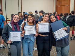 Four students hold certificates.