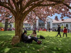 Two students sitting under a tree on Montclair State University's campus. The Open House events provide an opportunity for prospective students to experience campus life firsthand.