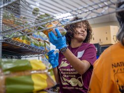 A Bonner Leader placing items on shelves at the food pantry of Saint Peter’s Haven, a nonprofit in Clifton dedicated to feeding the hungry and assisting the homeless.