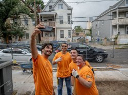 Montclair President Jonathan Koppell taking a selfie with three volunteers at a Habitat for Humanity construction site during the 9/11 Day of Service.