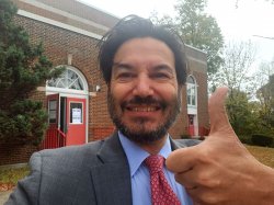 A selfie of President Koppell giving a thumbs up outside of his polling location, a red brick school building