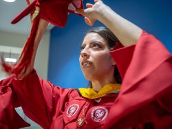 Andrea Uguna-Solano puts on her mortarboard.