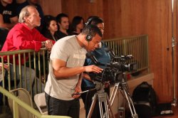 Broadcasting majors Randall Payton and Niki Santana shooting the event while news producer Steve McCarthy looks on.