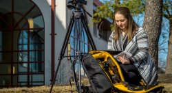 Journalism student Catherine Baxter sets up for a shoot with a mobile media backpack.