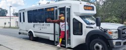 Picture of Rocky the Red Hawk at the door of a campus shuttle bus.