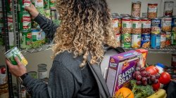 student reaching for canned goods on shelf