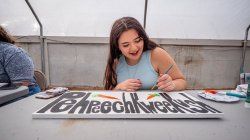 Female student paints sign.
