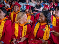 Students laughing and smiling during commencement.