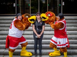 Hannah Lindeblad stands between two former students in Rocky and Roxy costumes.