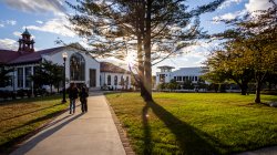 Students walking in front of Cole Hall at sunset