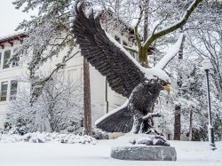 Montclair State University bronze red hawk statue and surrounding campus area blanketed in snow.