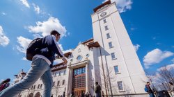 Student walking toward the University Hall tower