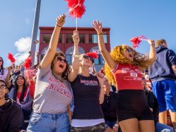 Students cheering in the stands at the homecoming football game